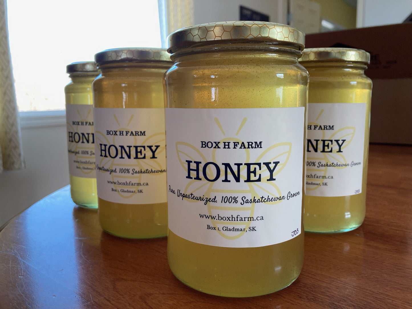 Large glass jars of liquid honey from box h farm